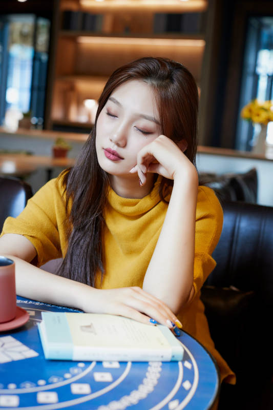 在图书咖啡馆阅读书籍的少女图片