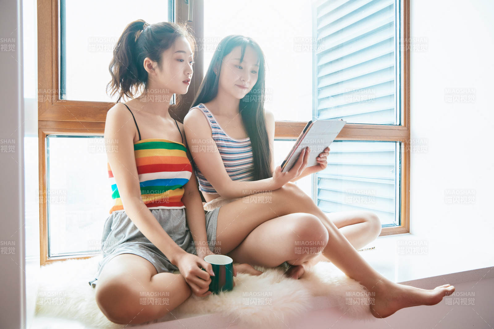 午后坐在飘窗上追剧休息的闺蜜少女图片