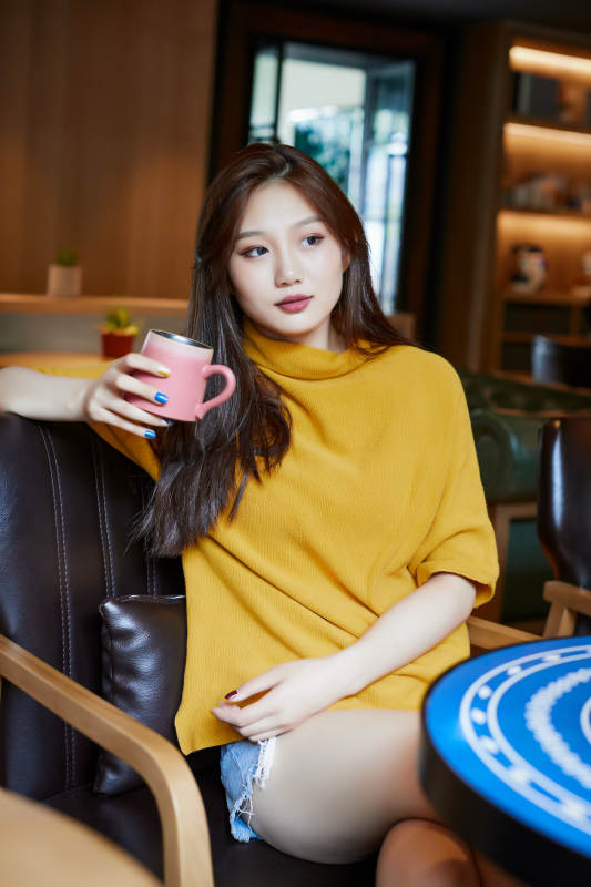 在图书咖啡馆阅读书籍的少女图片