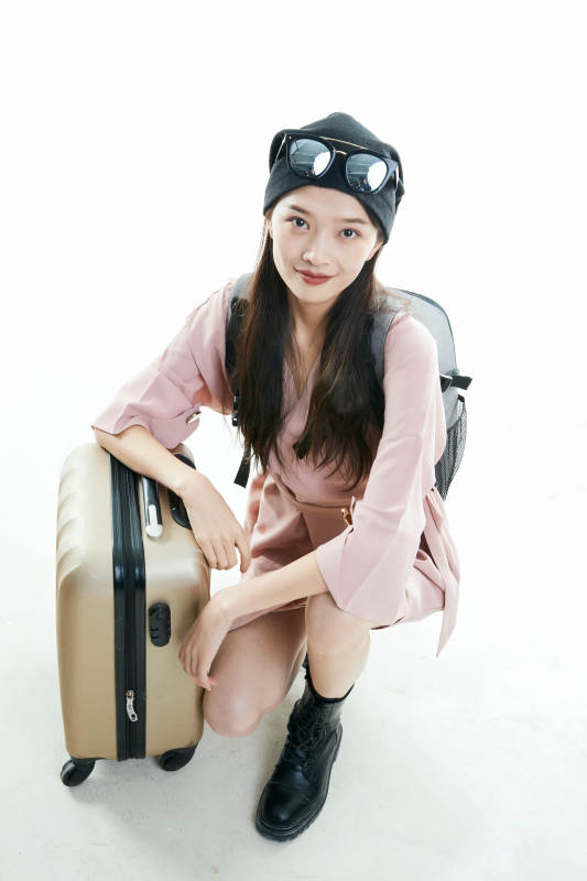白色背景下准备出发旅行的美丽东方女大学生图片
