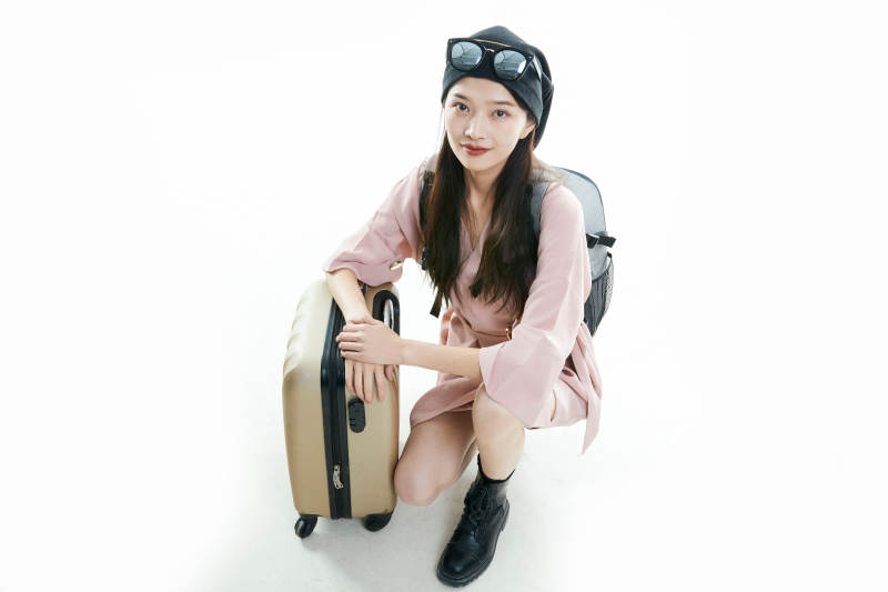 白色背景下准备出发旅行的美丽东方女大学生图片