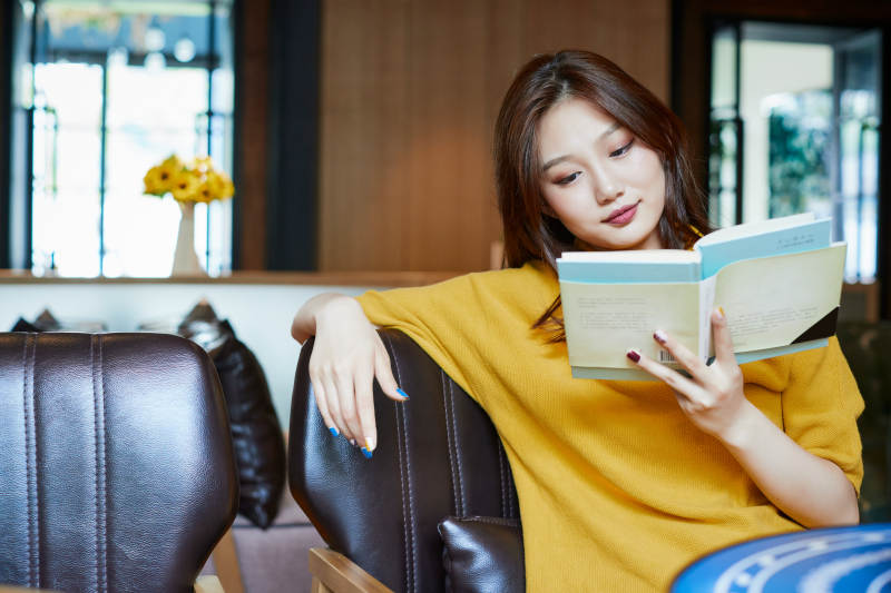 在图书咖啡馆阅读书籍的少女图片