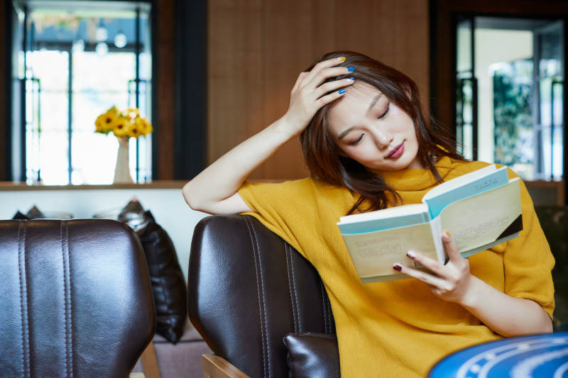 在图书咖啡馆阅读书籍的少女图片