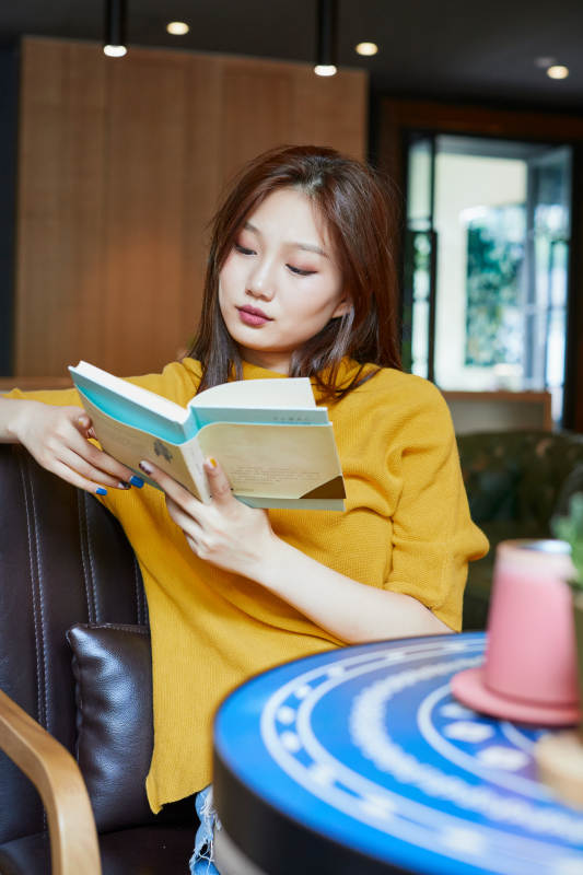 在图书咖啡馆阅读书籍的少女图片