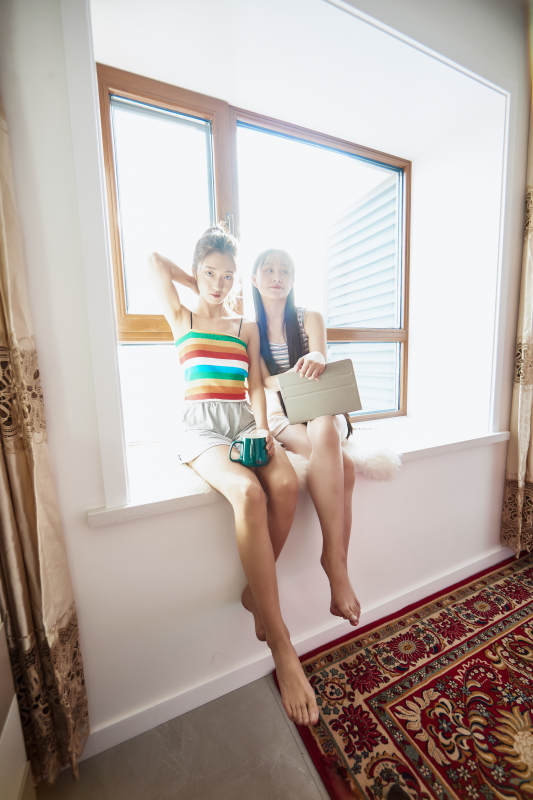 午后坐在飘窗上追剧休息的闺蜜少女图片