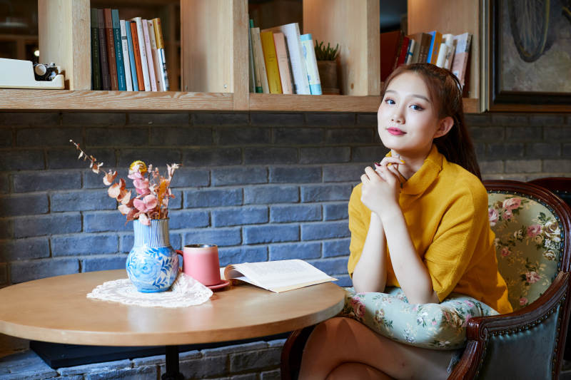 在图书咖啡馆阅读书籍的少女图片