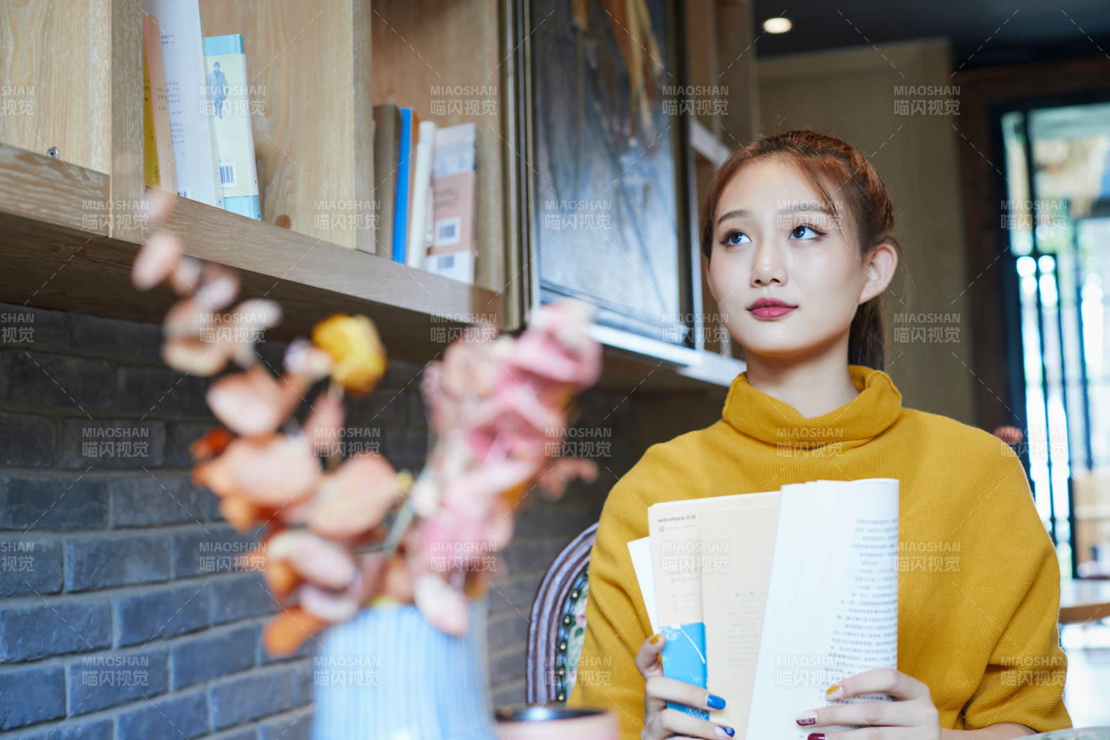 在图书咖啡馆阅读书籍的少女图片