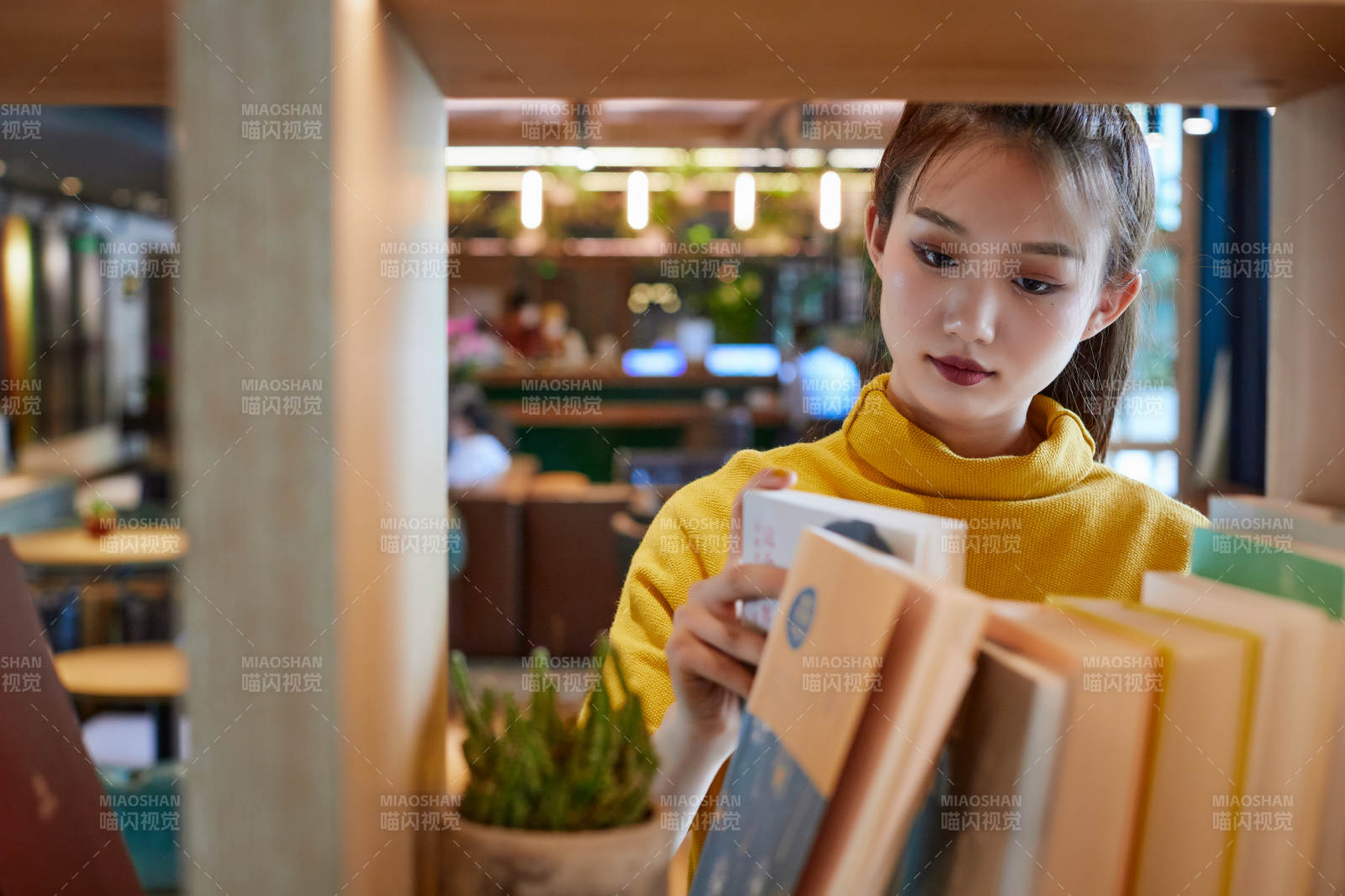 在图书咖啡馆阅读书籍的少女图片