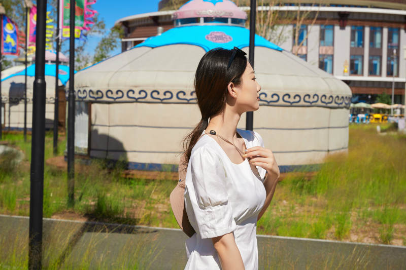 草原湿地公园游玩拍照的亚洲少女图片