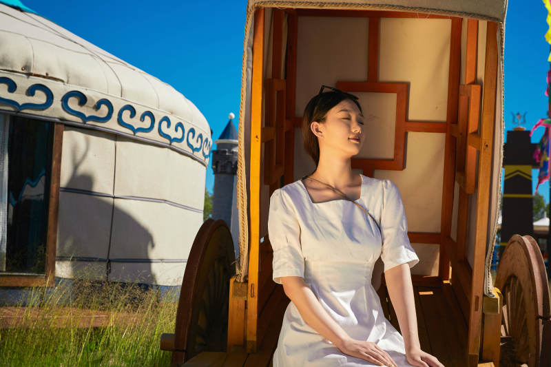 草原湿地公园游玩拍照的亚洲少女图片