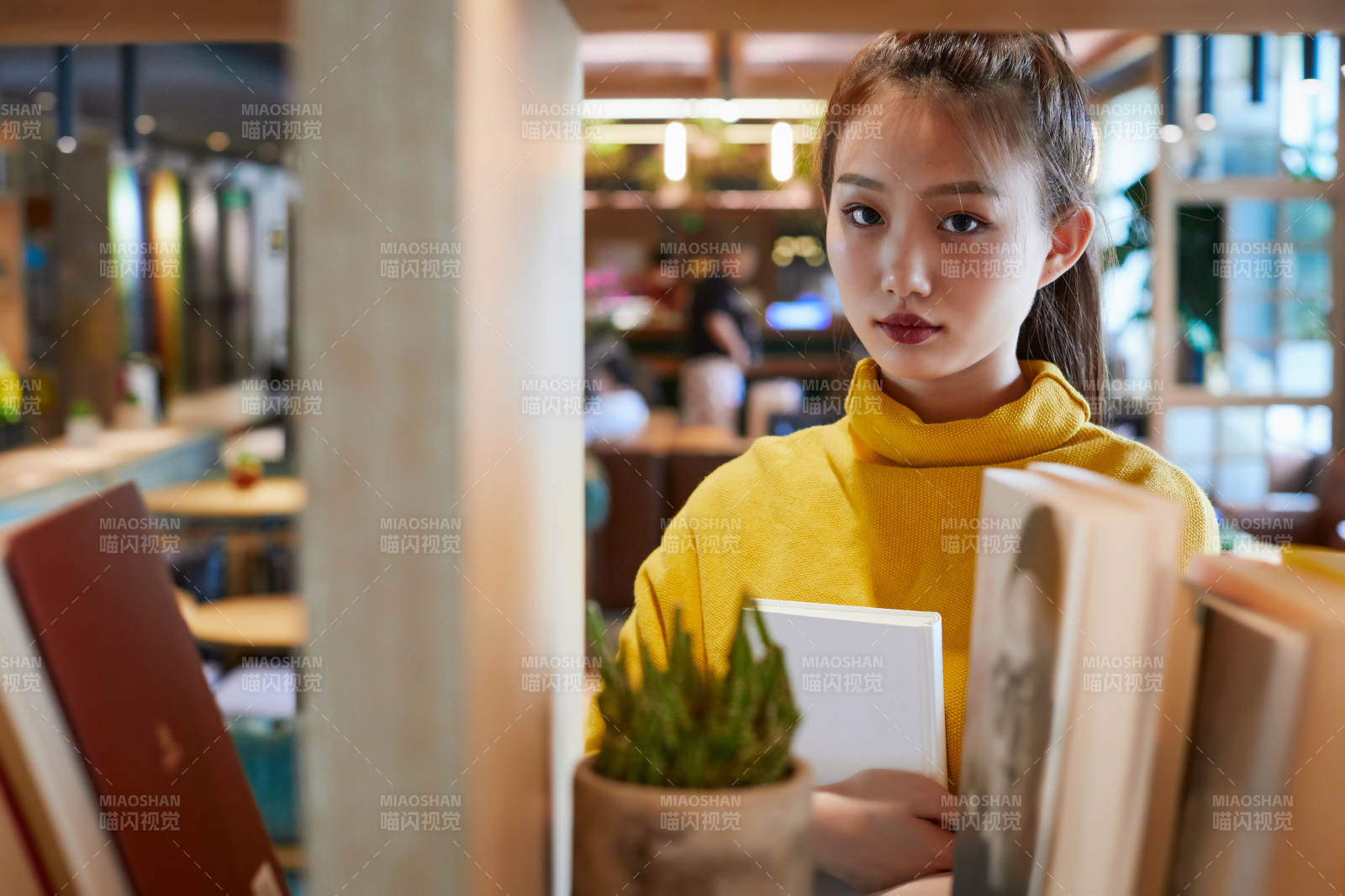 在图书咖啡馆阅读书籍的少女图片