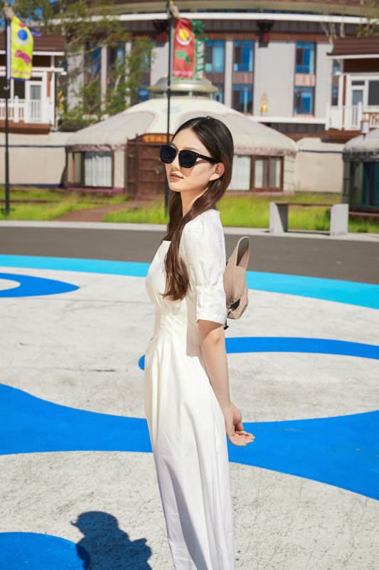 草原湿地公园游玩拍照的亚洲少女图片