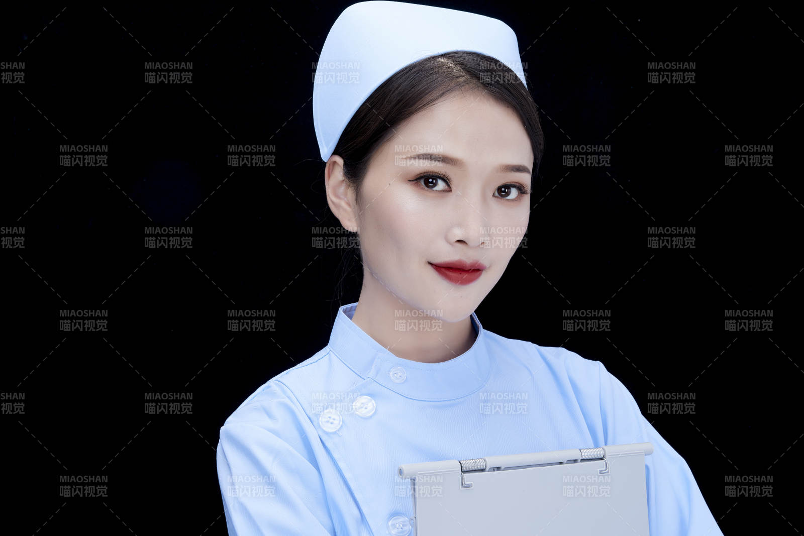 白背景里穿蓝色护士服手持病历夹的美女护士图片