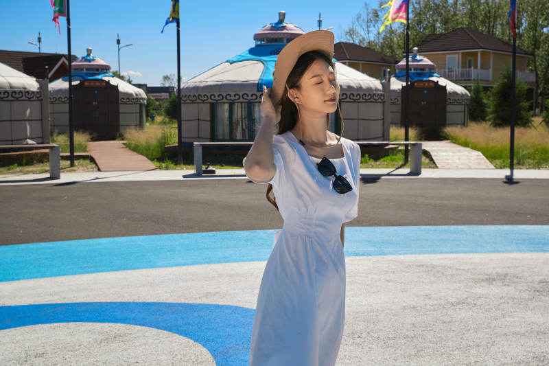 草原湿地公园游玩拍照的亚洲少女图片