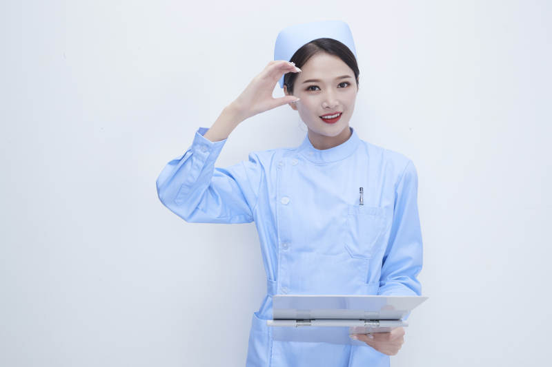 白背景里穿蓝色护士服手持病历夹的美女护士图片