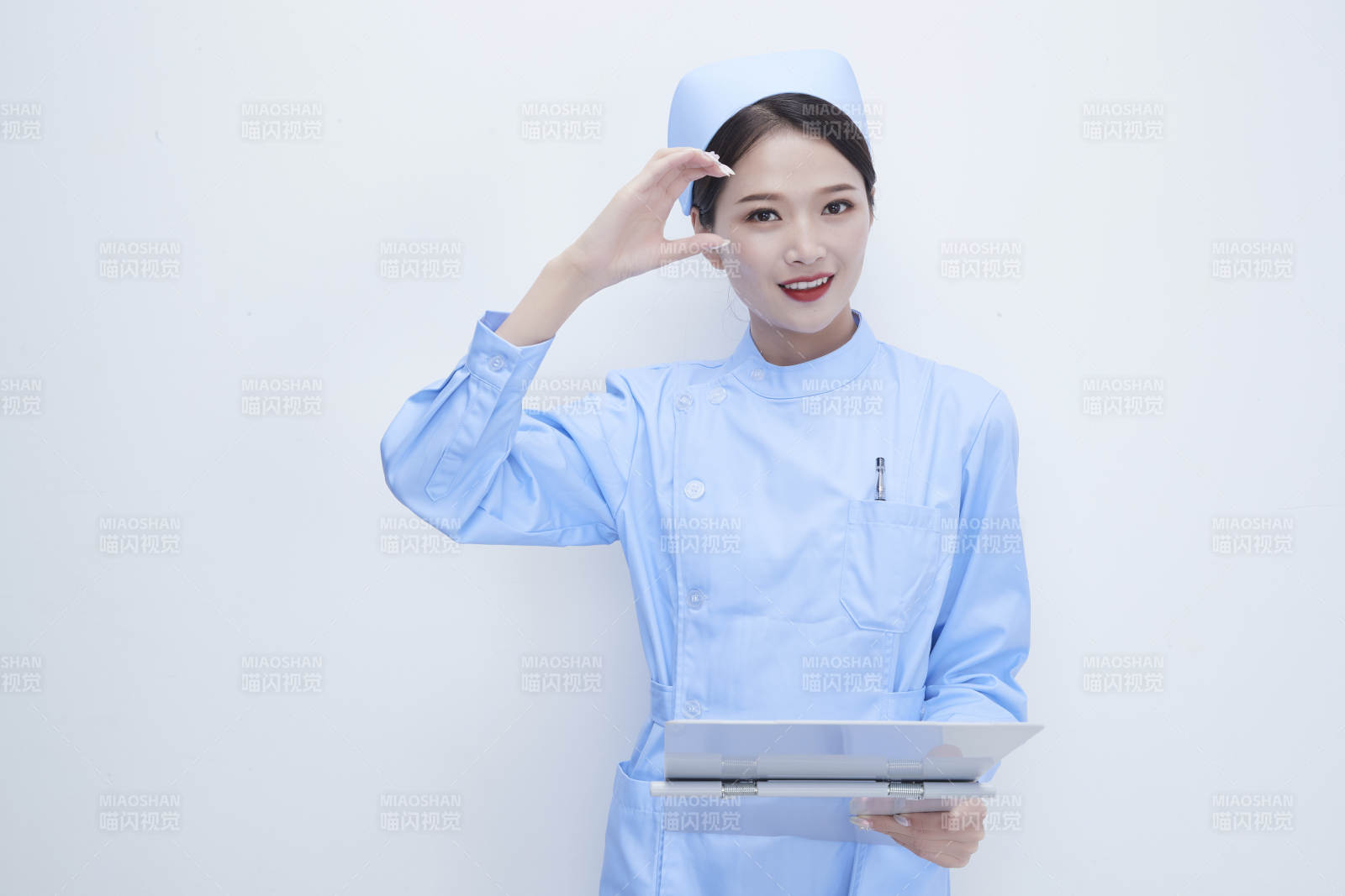 白背景里穿蓝色护士服手持病历夹的美女护士图片