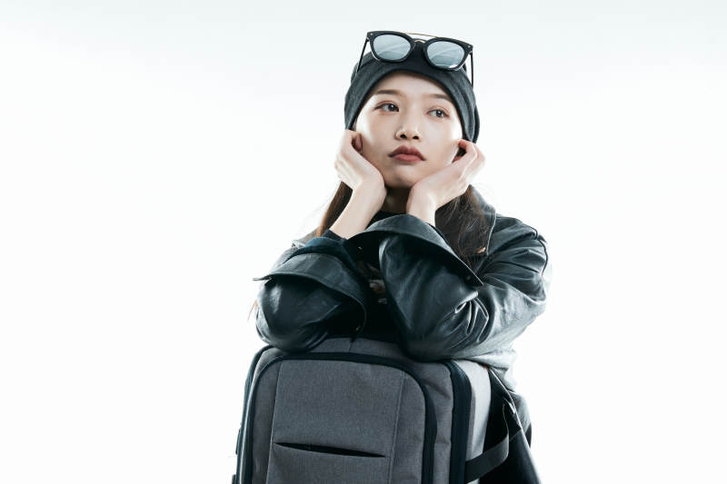 白色背景下准备出发旅行的美丽东方女大学生图片