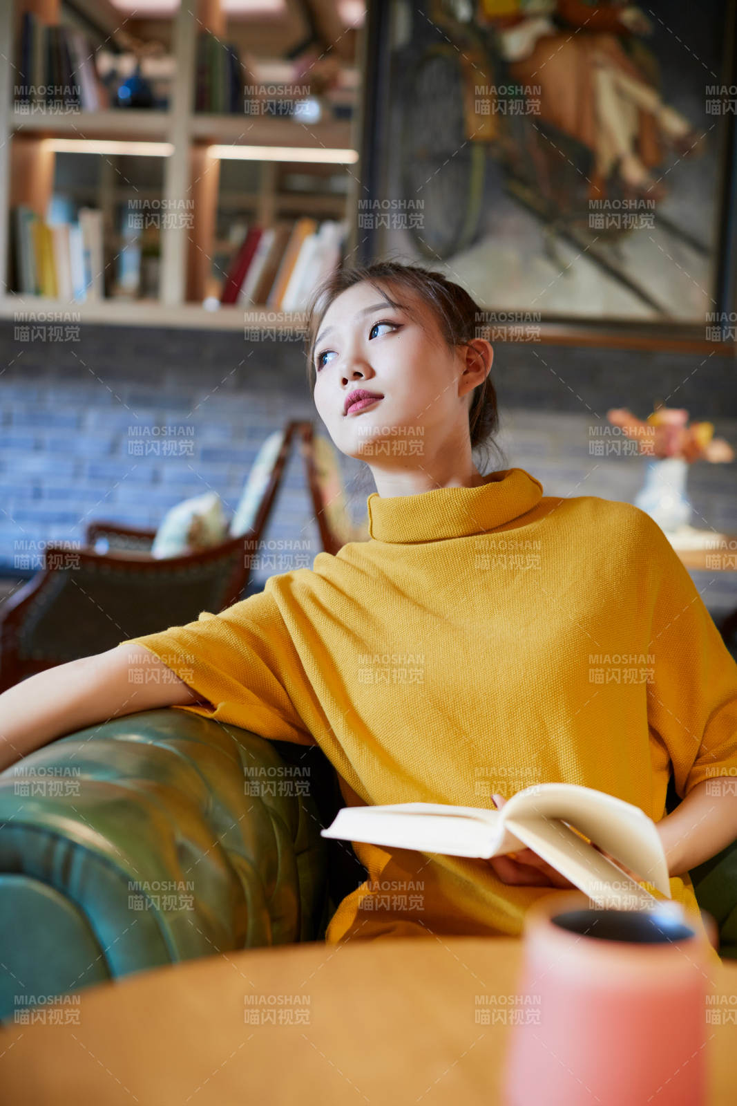 在图书咖啡馆阅读书籍的少女图片