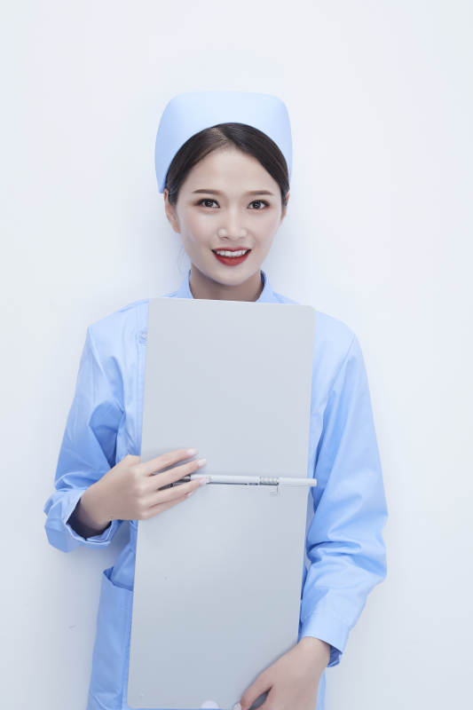 白背景里穿蓝色护士服手持病历夹的美女护士图片