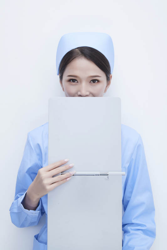 白背景里穿蓝色护士服手持病历夹的美女护士图片