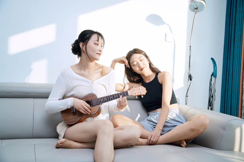 坐在沙发弹琴唱歌俩位美女闺蜜图片