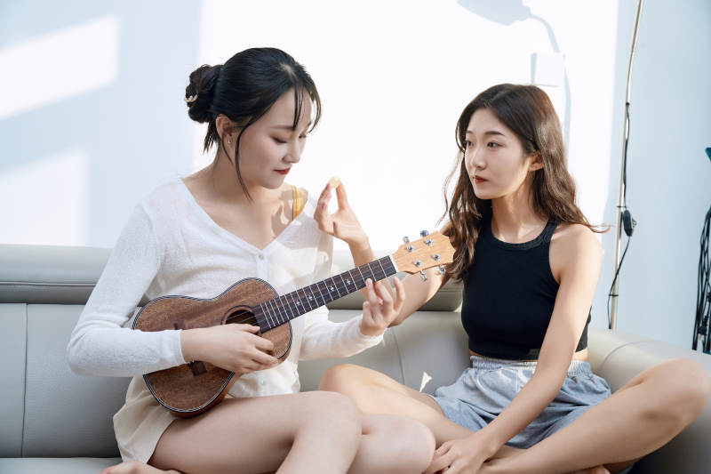 坐在沙发弹琴唱歌俩位美女闺蜜图片