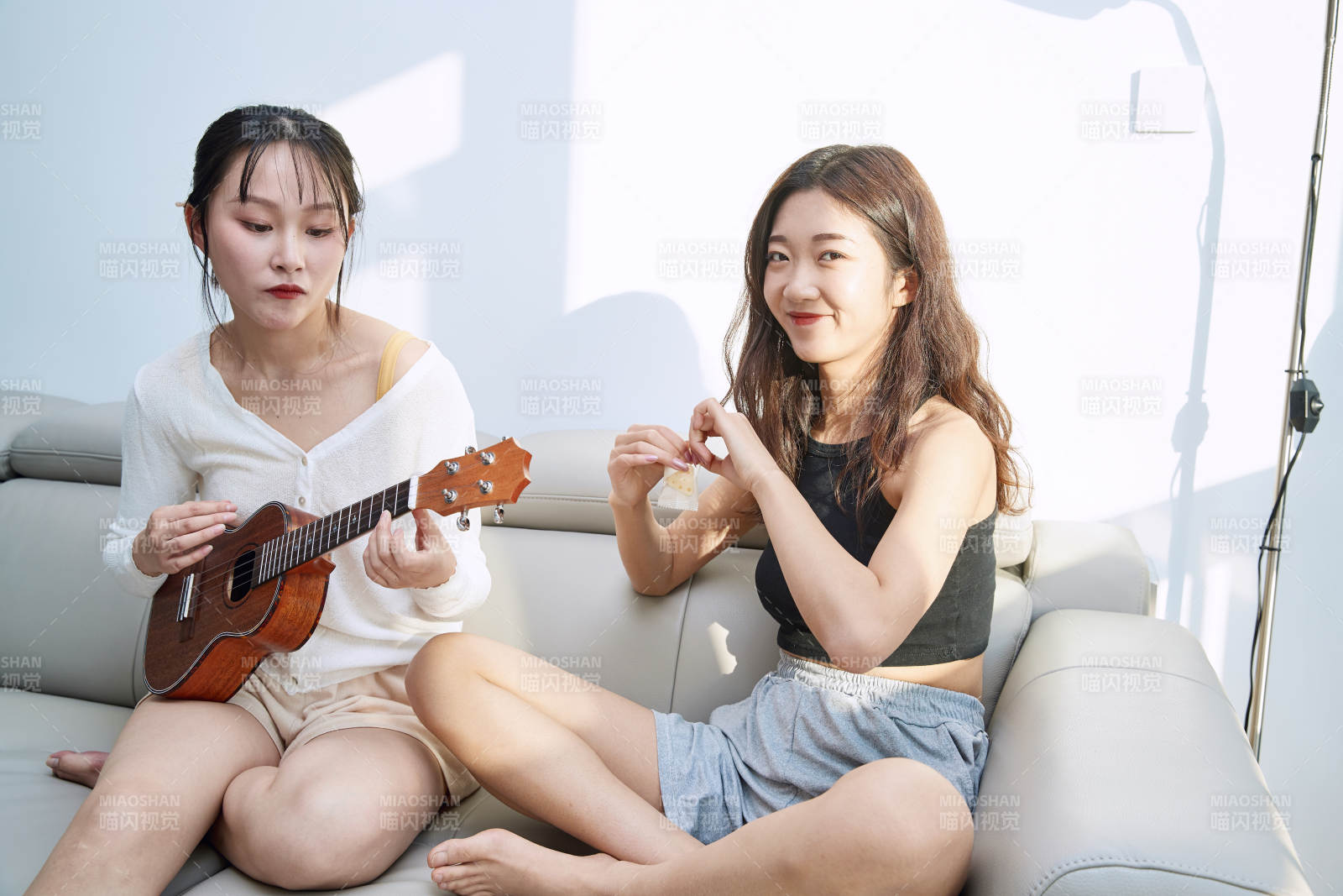 坐在沙发弹琴唱歌俩位美女闺蜜图片