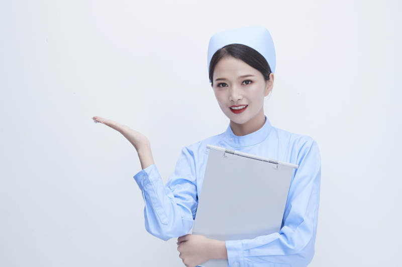 白背景里穿蓝色护士服手持病历夹的美女护士图片