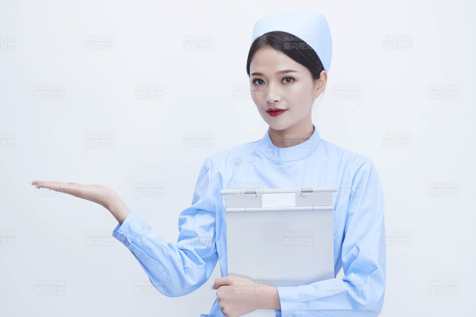 白背景里穿蓝色护士服手持病历夹的美女护士图片