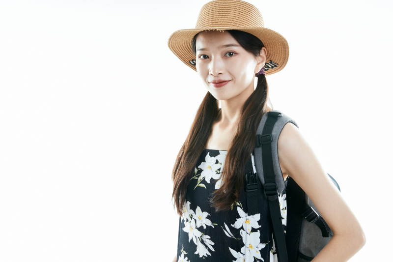 白色背景下准备出发旅行的美丽东方女大学生图片