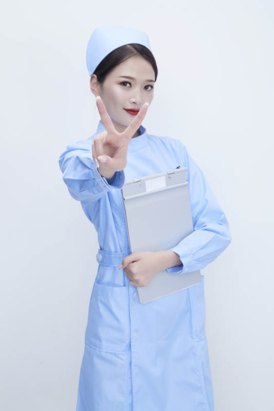 白背景里穿蓝色护士服手持病历夹的美女护士图片