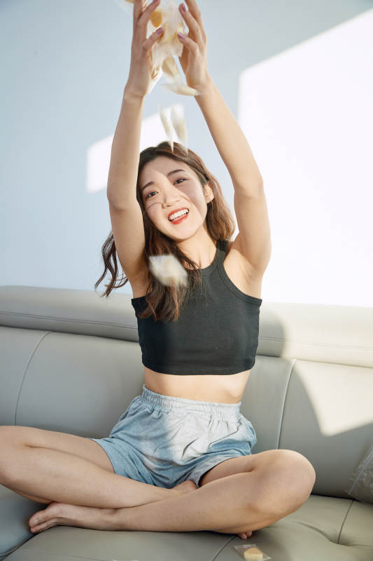 在家在沙发上享受美食的亚洲少女图片