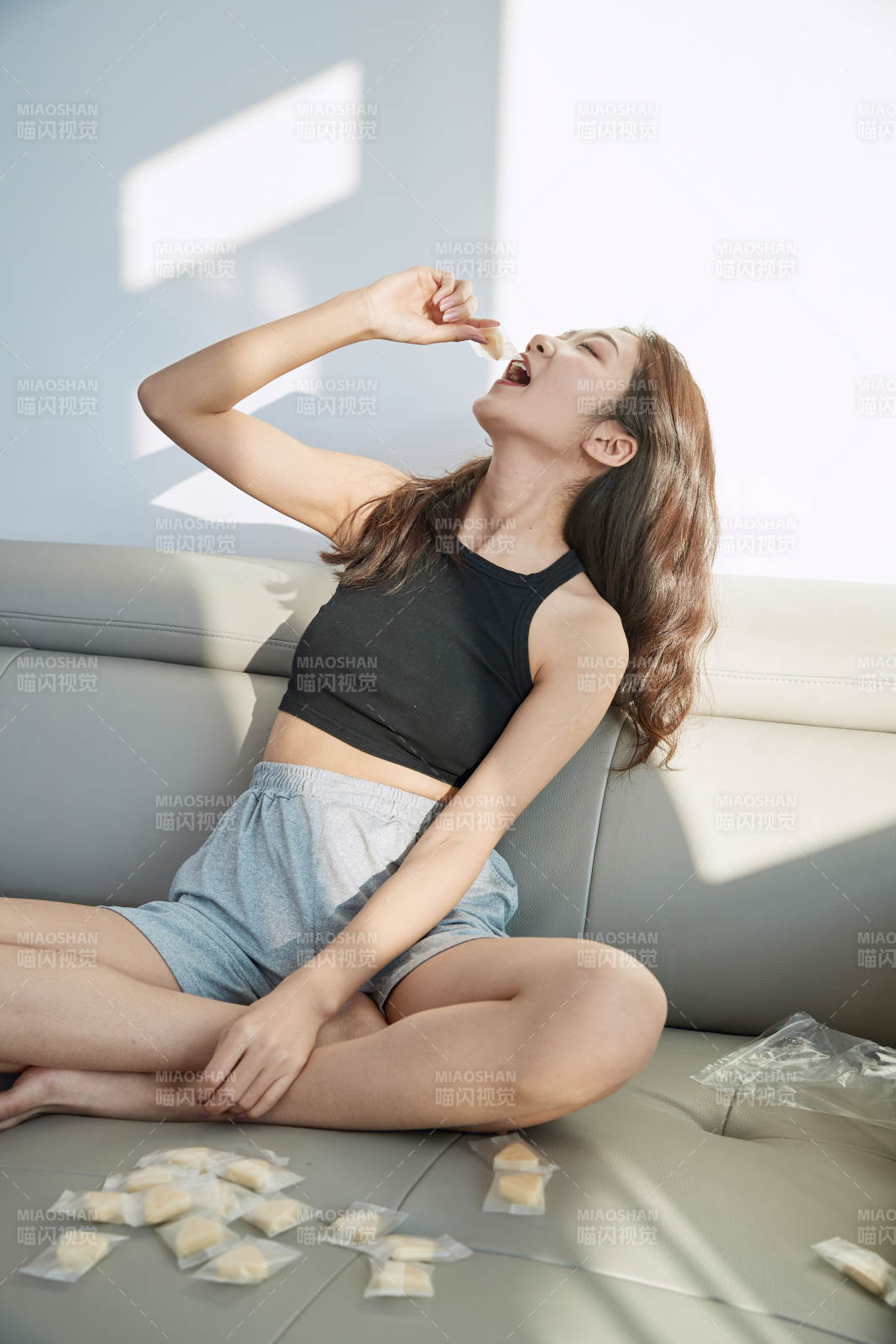 在家在沙发上享受美食的亚洲少女图片