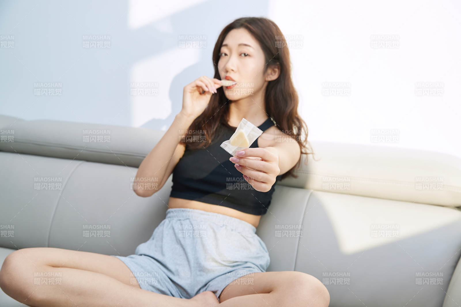 在家在沙发上享受美食的亚洲少女图片