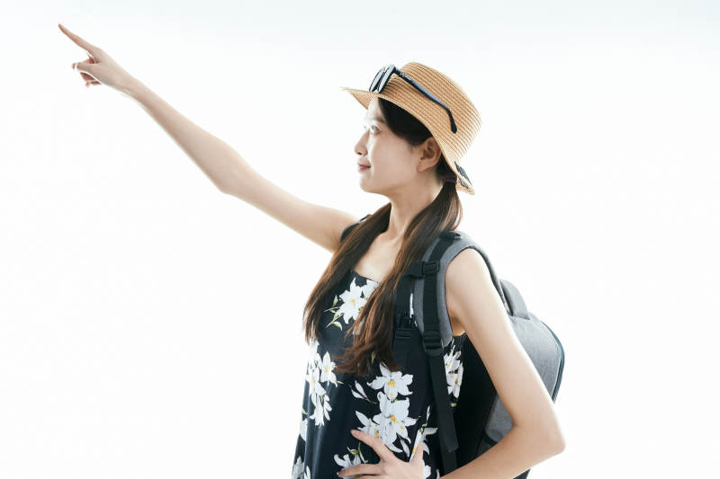 白色背景下准备出发旅行的美丽东方女大学生图片