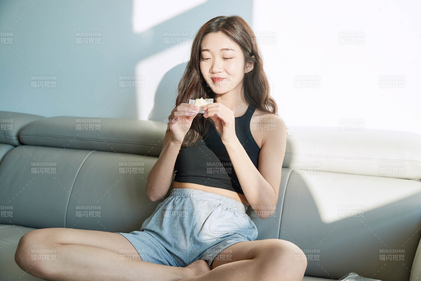 在家在沙发上享受美食的亚洲少女图片