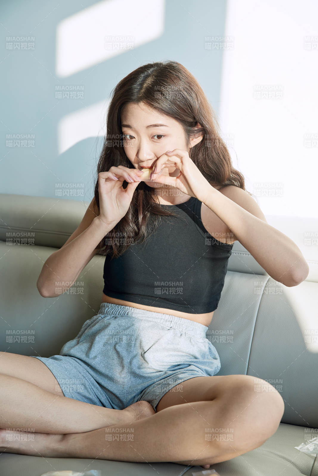 在家在沙发上享受美食的亚洲少女图片