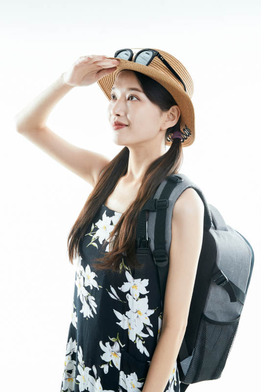 白色背景下准备出发旅行的美丽东方女大学生图片