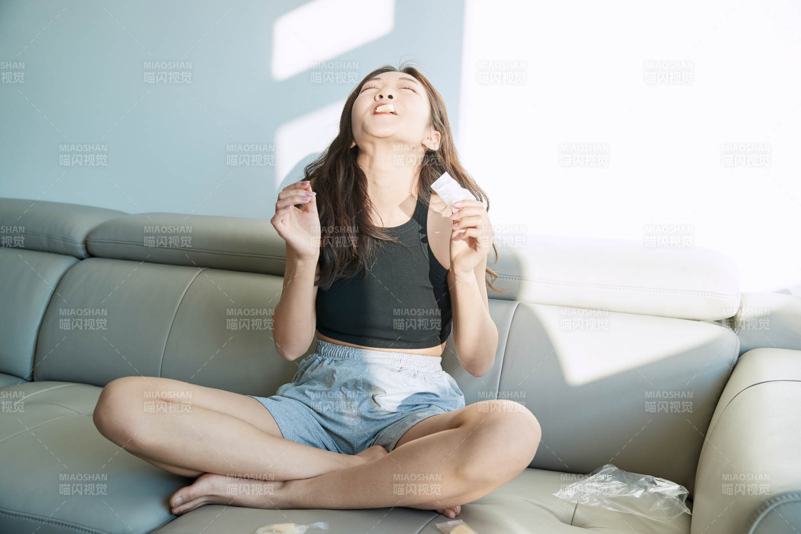 在家在沙发上享受美食的亚洲少女图片