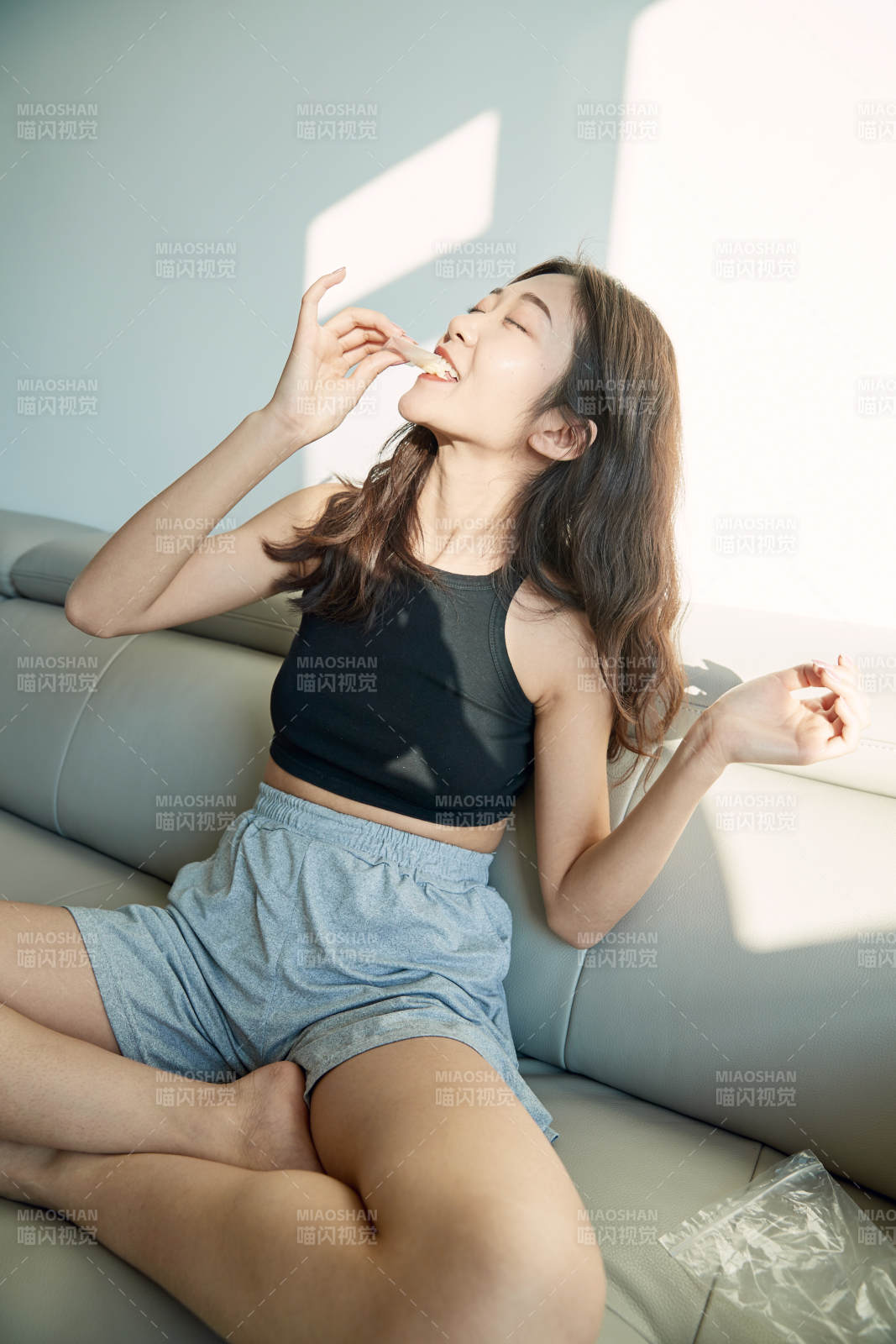 在家在沙发上享受美食的亚洲少女图片