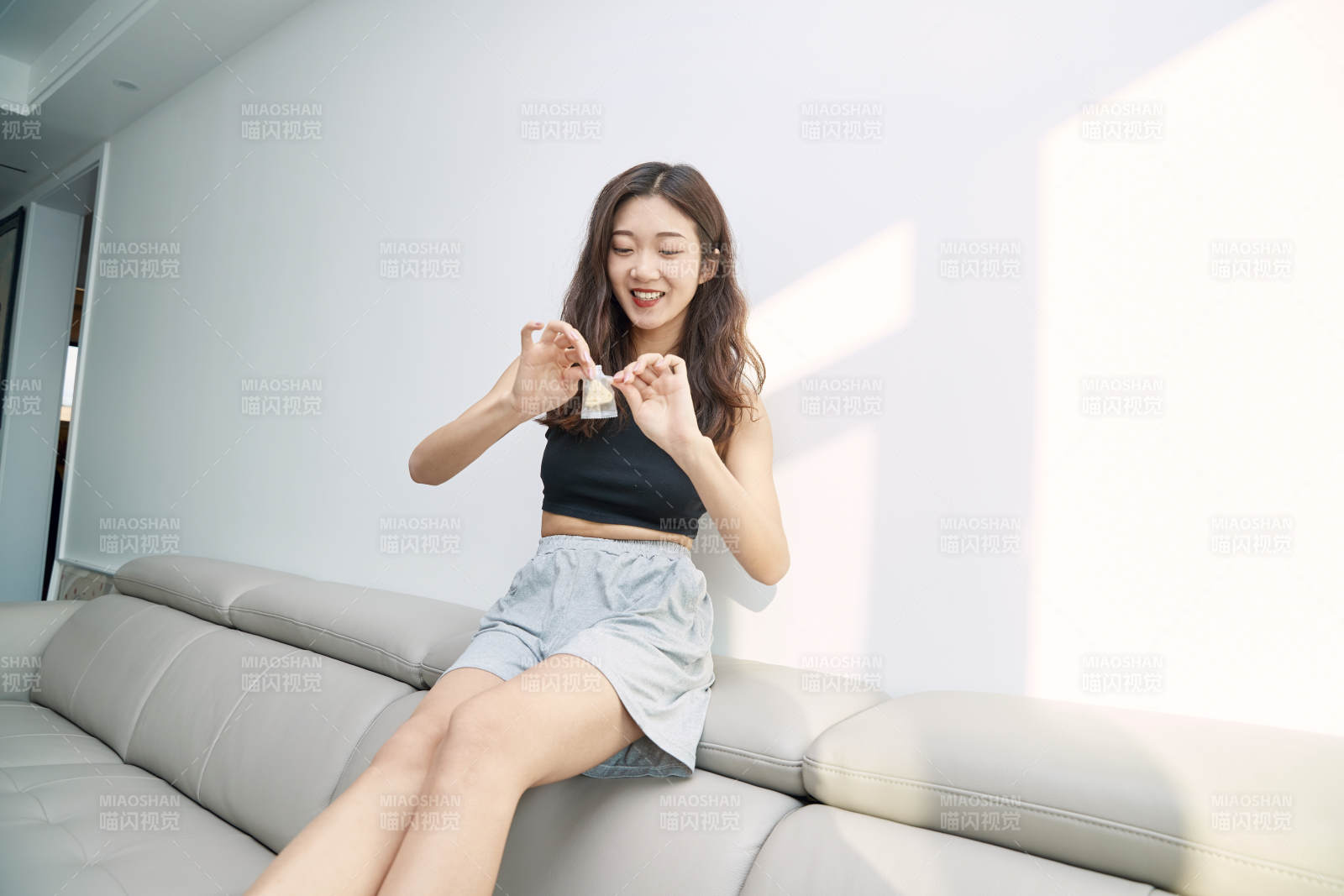 在家在沙发上享受美食的亚洲少女图片