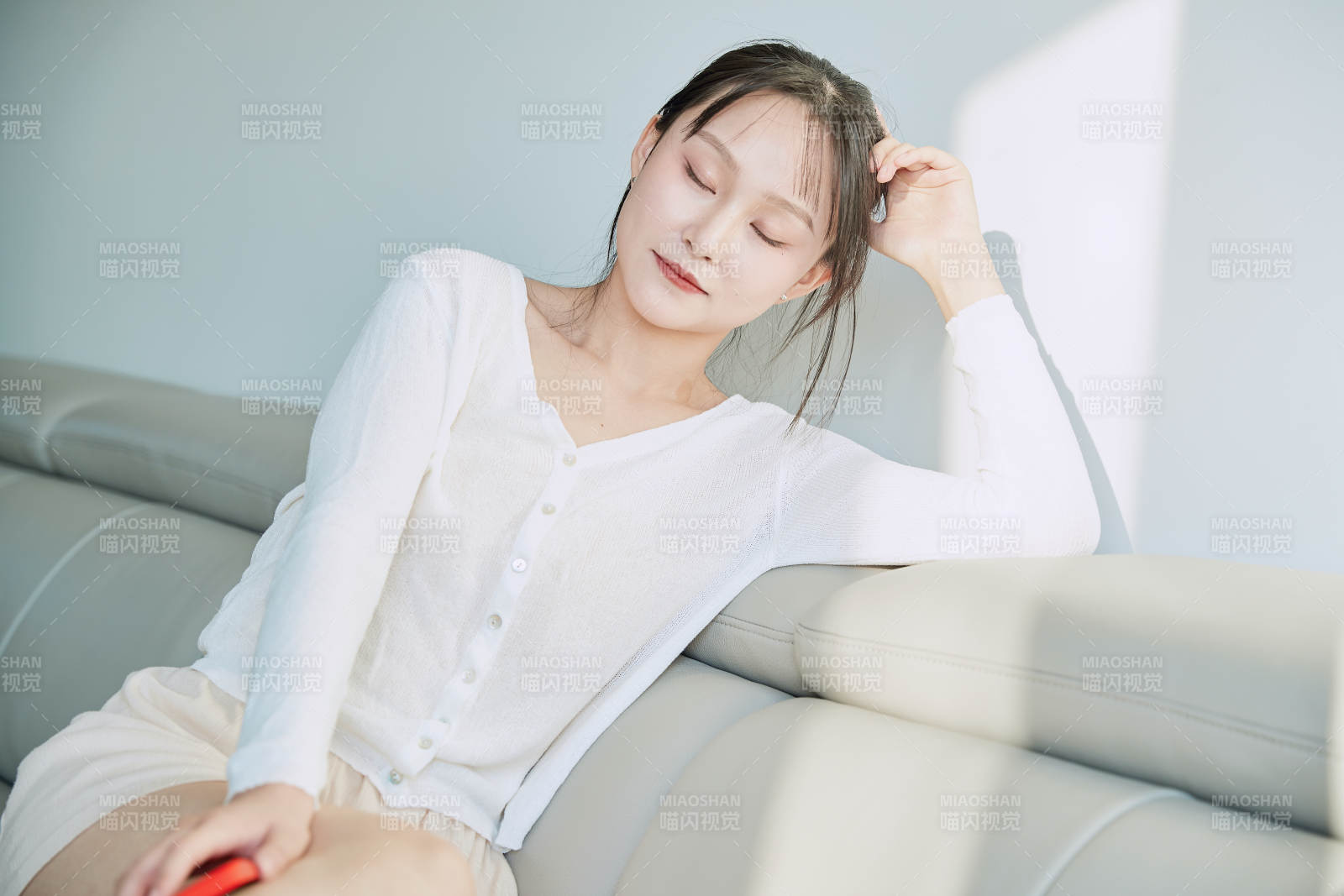 在沙发床上玩手机的年轻亚洲女性图片