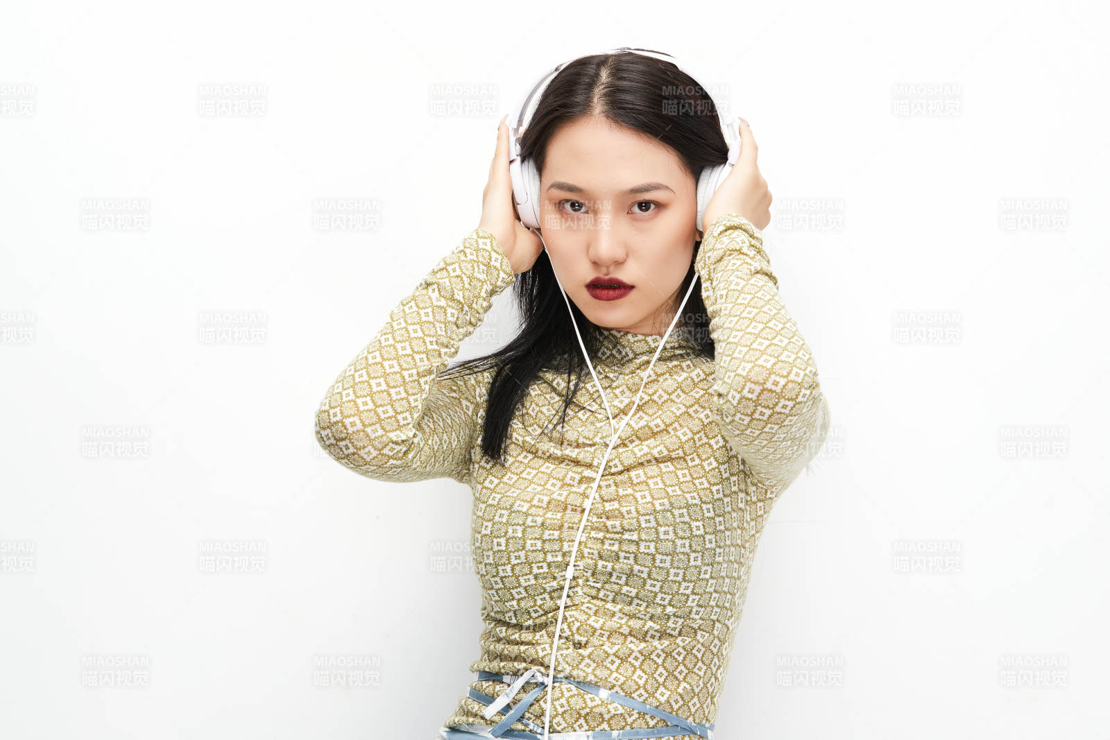 头戴耳机手持电话听音乐的少女图片