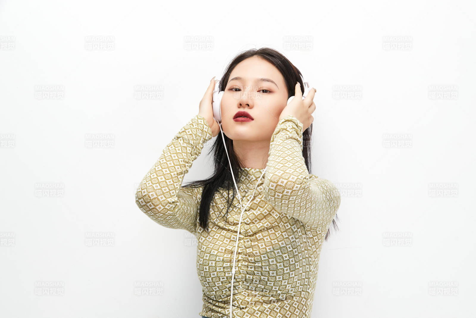 头戴耳机手持电话听音乐的少女图片