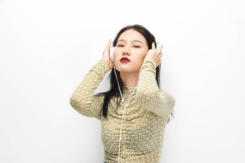 头戴耳机手持电话听音乐的少女图片