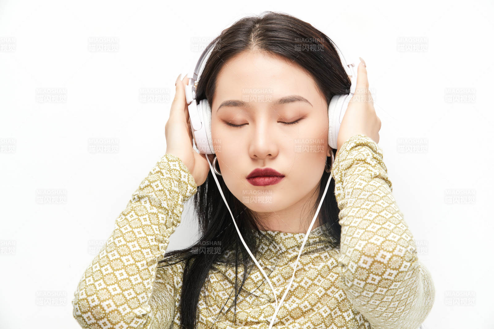 头戴耳机手持电话听音乐的少女图片