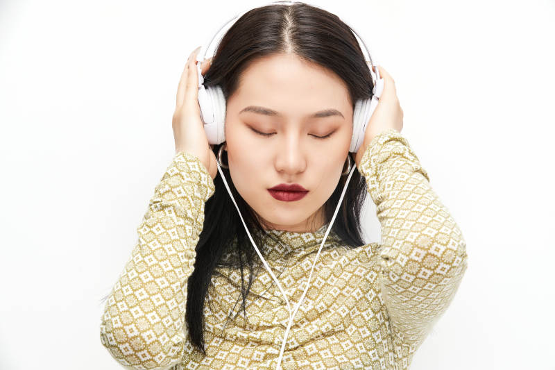 头戴耳机手持电话听音乐的少女图片