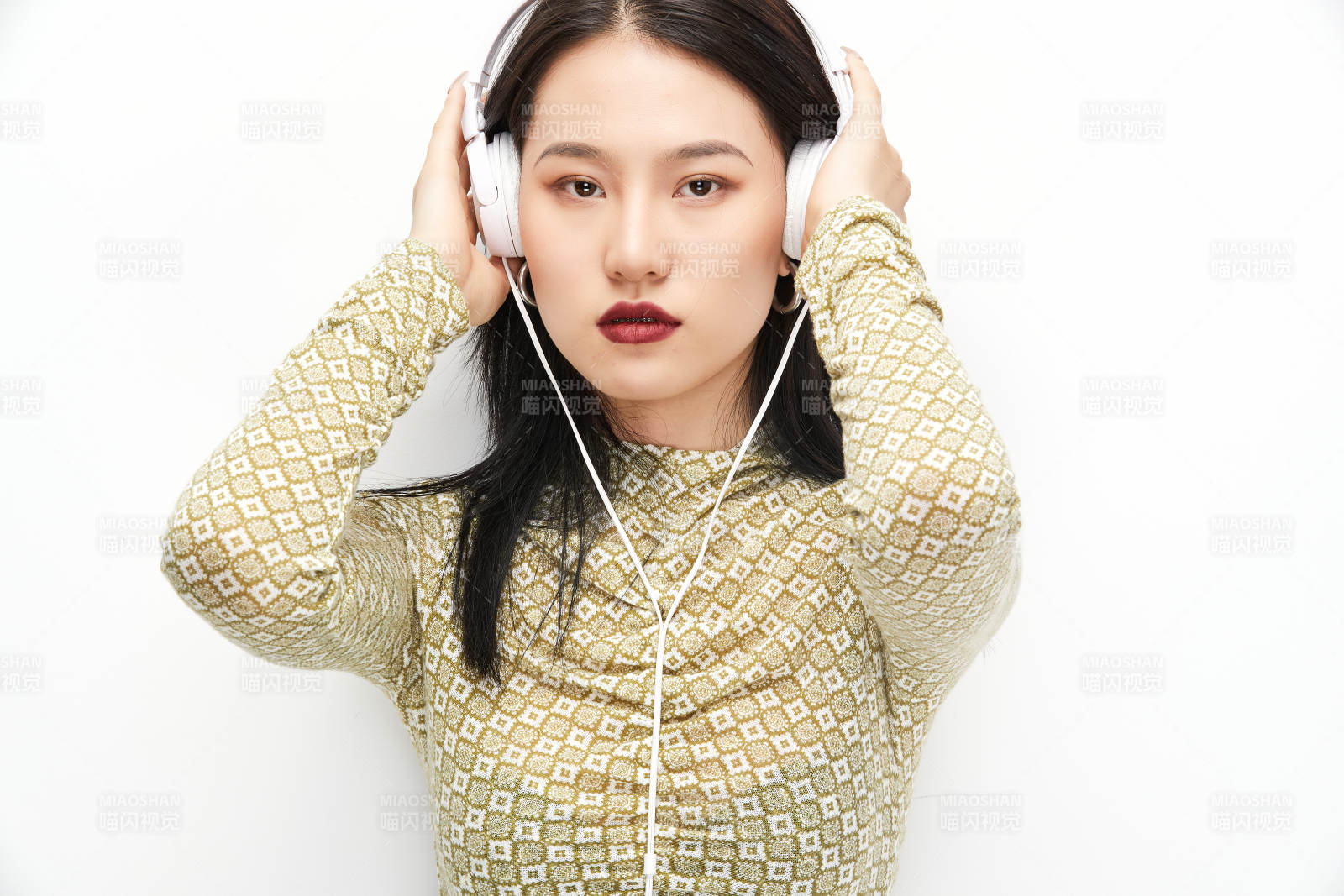 头戴耳机手持电话听音乐的少女图片