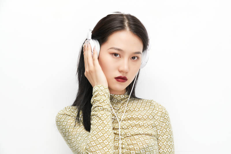 头戴耳机手持电话听音乐的少女图片