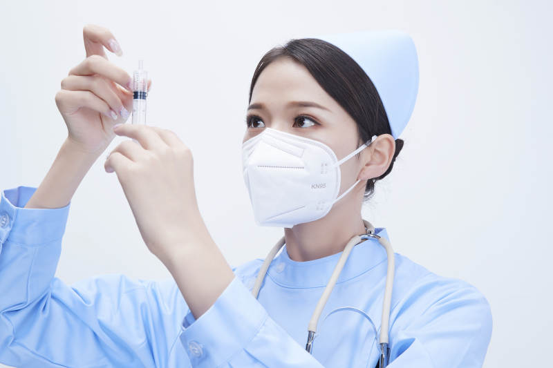 穿护士服戴听诊器口罩和手执针筒的美女护士图片